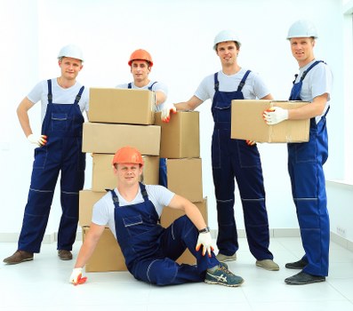 Professional movers handling furniture in a West London flat building